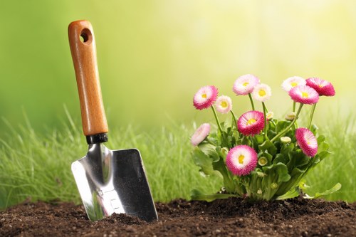 Gardener pruning a plant in a well-kept garden